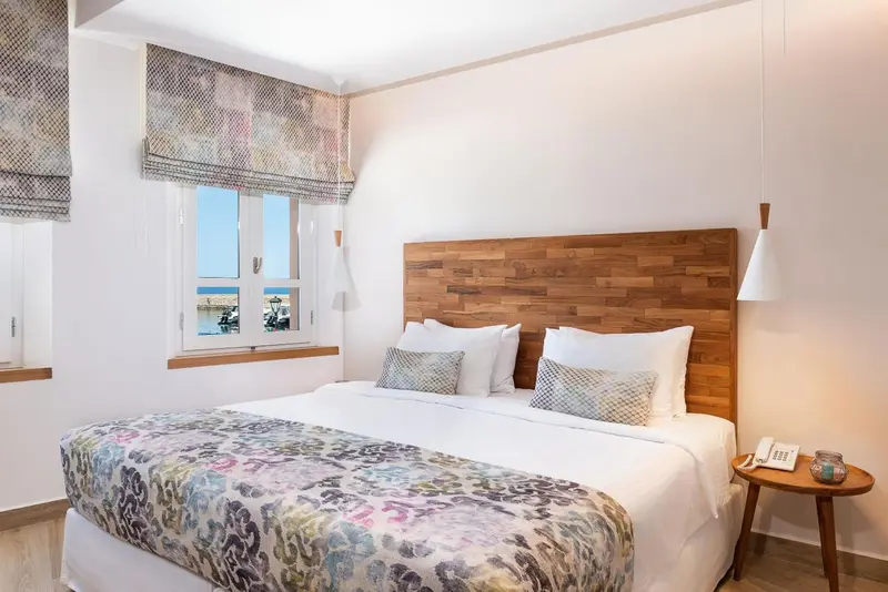 Une chambre lumineuse avec un grand lit et une fenêtre.