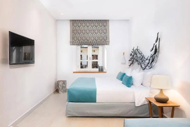 Une chambre lumineuse avec un grand lit et une décoration murale.
