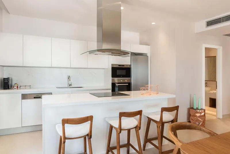 Cuisine moderne avec îlot central et tabourets.