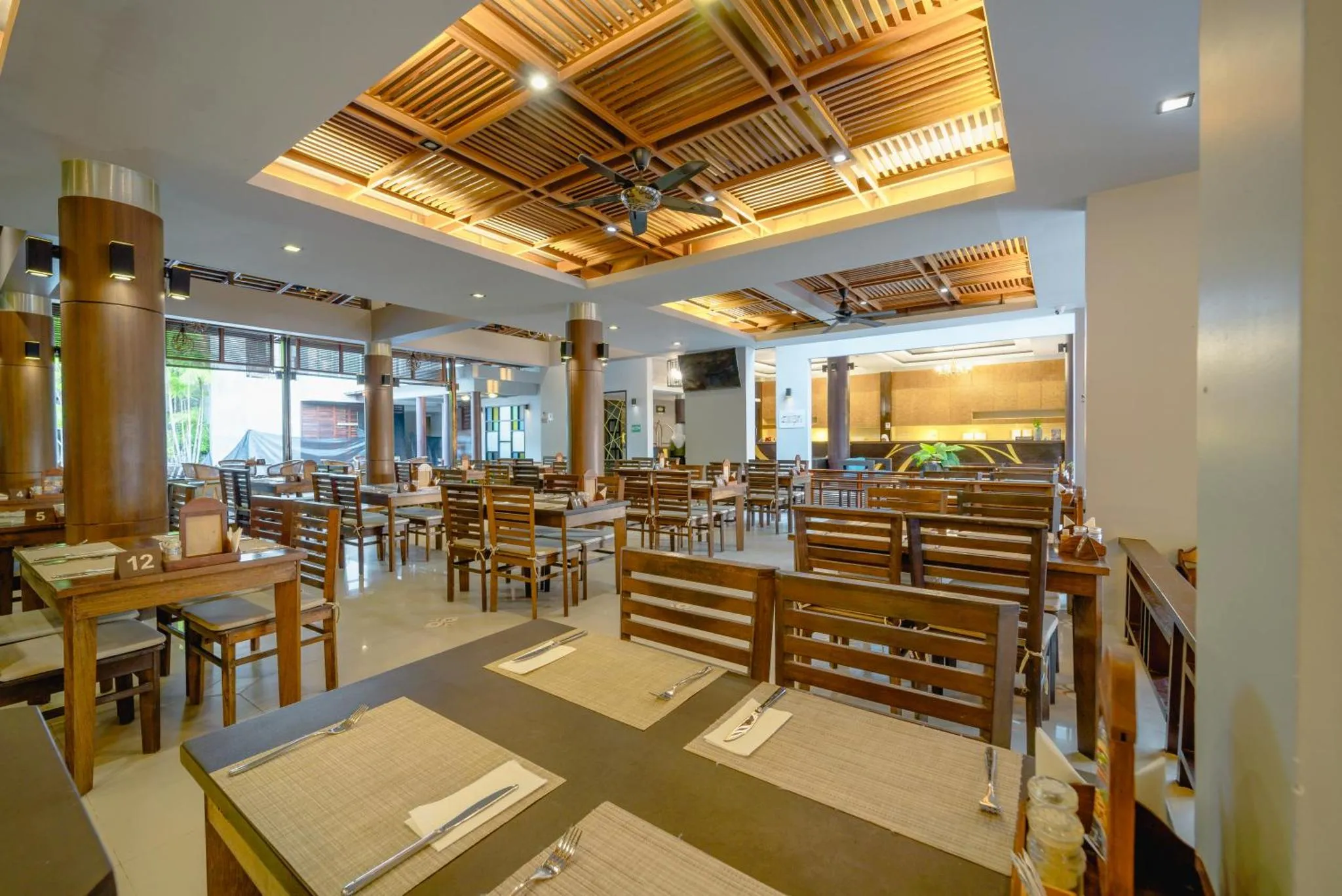 Une salle lumineuse avec des tables dressées pour un repas.