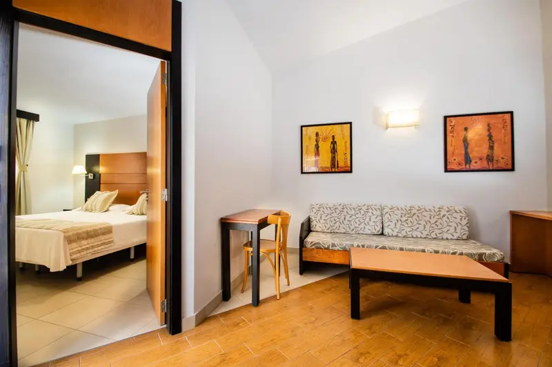Une chambre avec un coin salon et une table basse.