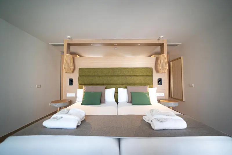 Une chambre moderne avec un grand lit et une décoration sobre.
