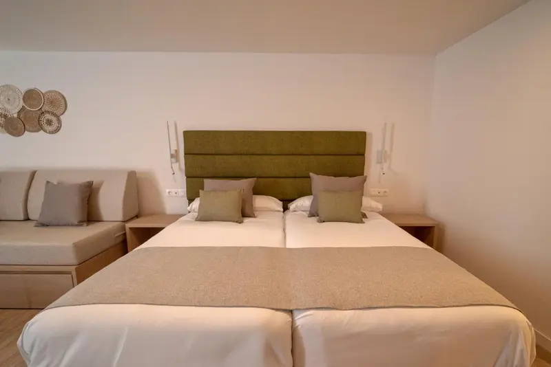 Une chambre lumineuse avec un grand lit et un canapé.