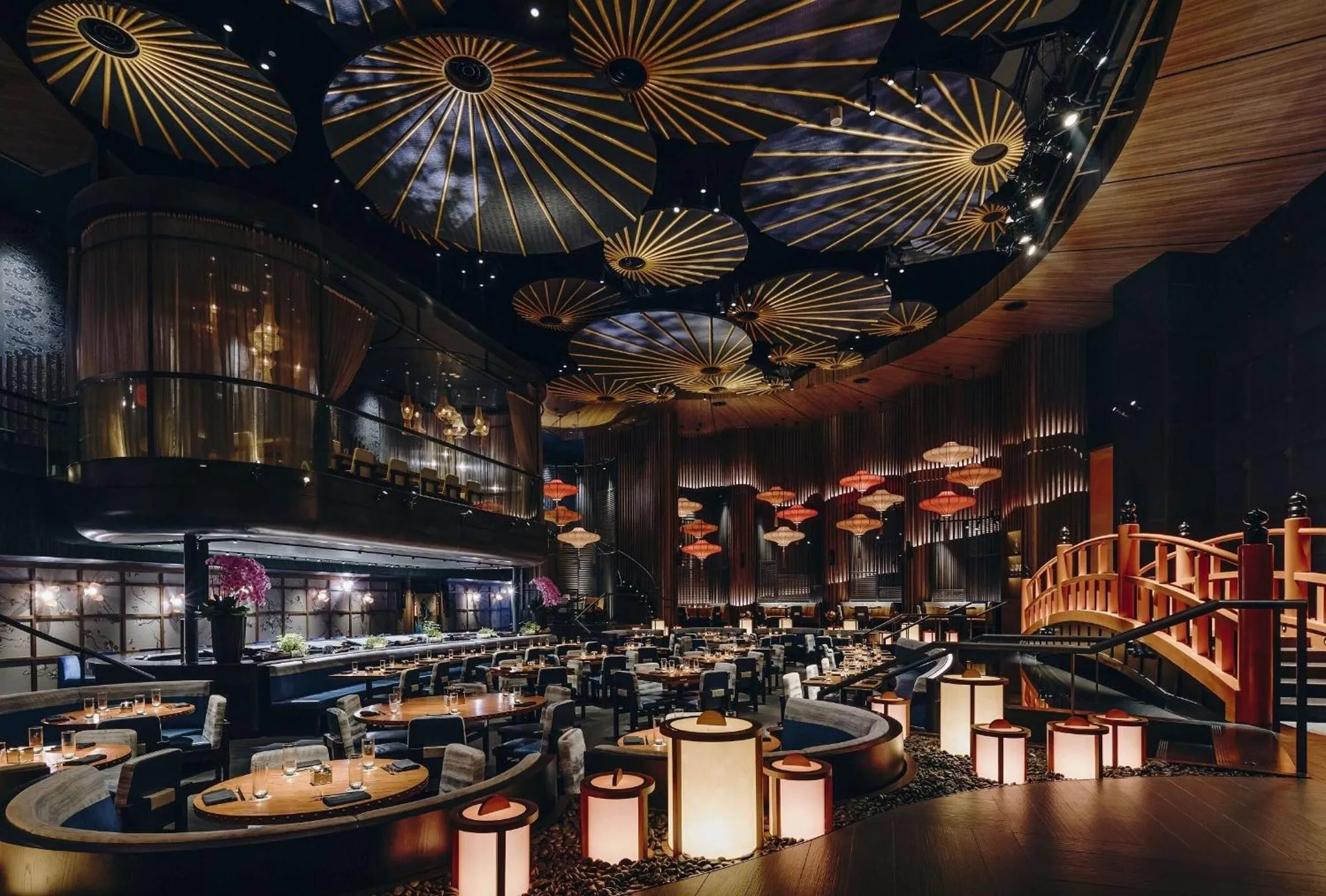 Une salle de restaurant spacieuse avec des tables éclairées et une décoration asiatique.