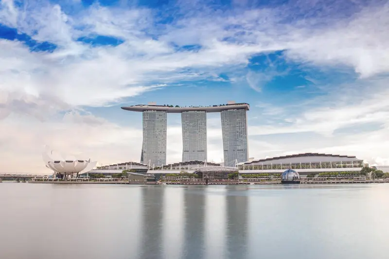 Architecture moderne avec trois tours reliées par une plateforme supérieure.