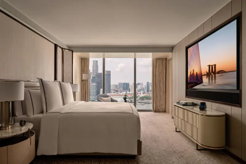 Chambre moderne avec un grand lit et une vue sur la ville.