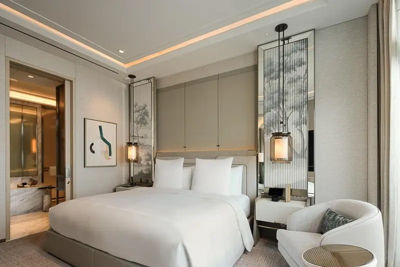 Une chambre d'hotel moderne avec un grand lit et un fauteuil.