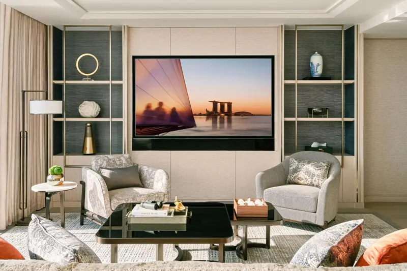Un salon moderne avec deux fauteuils confortables et une télévision murale.