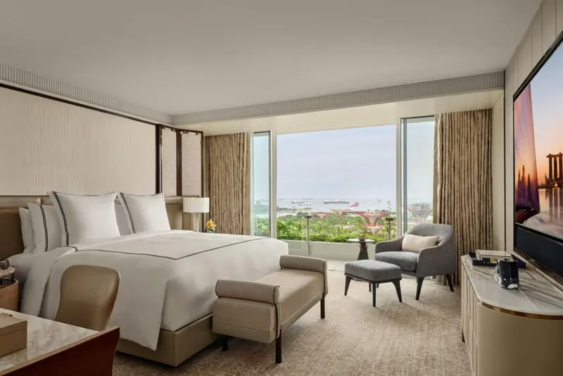 Une chambre lumineuse avec un grand lit et une vue sur la mer.