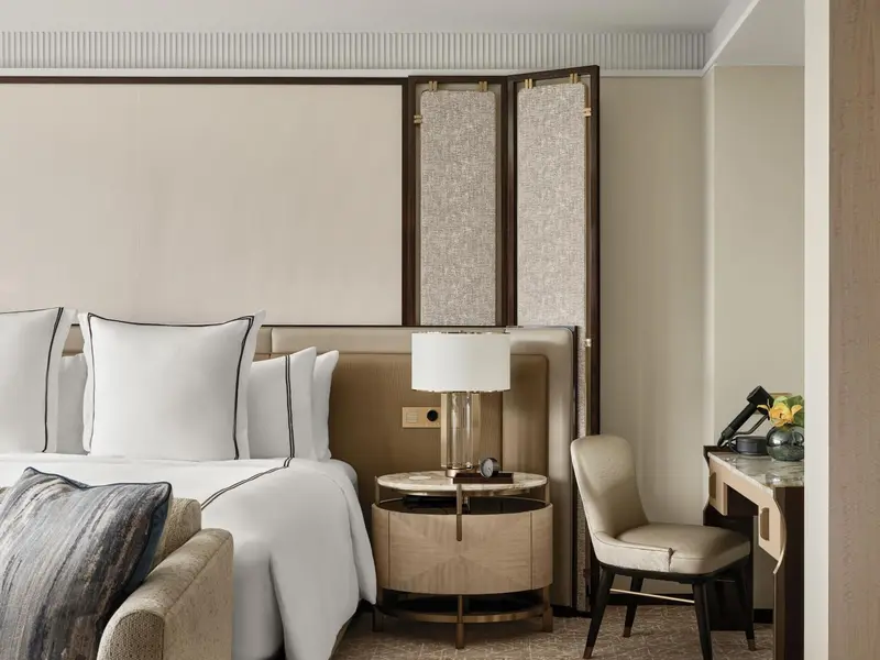 Une chambre lumineuse avec un grand lit et une table de chevet.