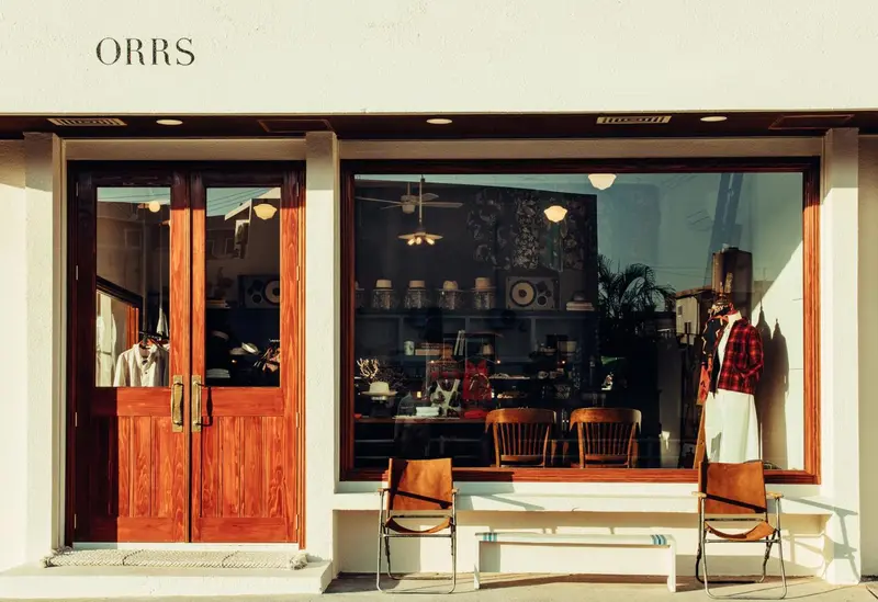 Façade d'un commerce avec une vitrine et une porte d'entrée en bois.