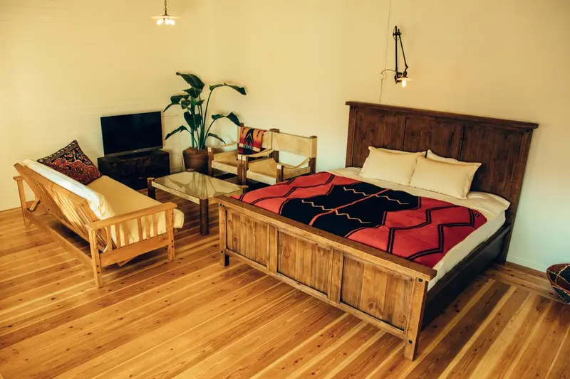 Une chambre lumineuse avec un lit et un coin salon.
