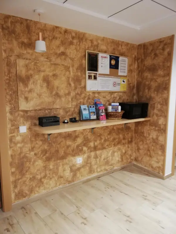 Un comptoir d'accueil avec des brochures et des objets décoratifs sur un meuble en bois.