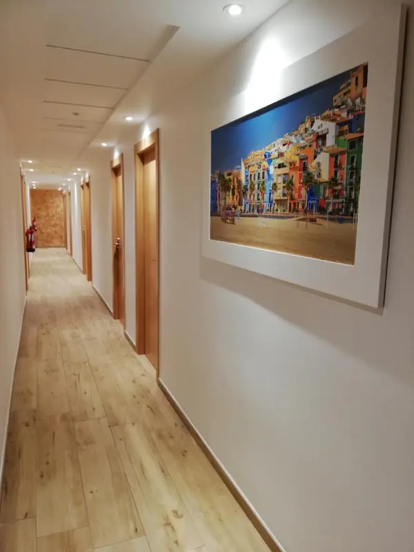Couloir d'hôtel avec une œuvre d'art représentant une ville côtière.