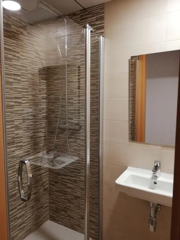 Douche à l'italienne dans une salle de bain carrelée.