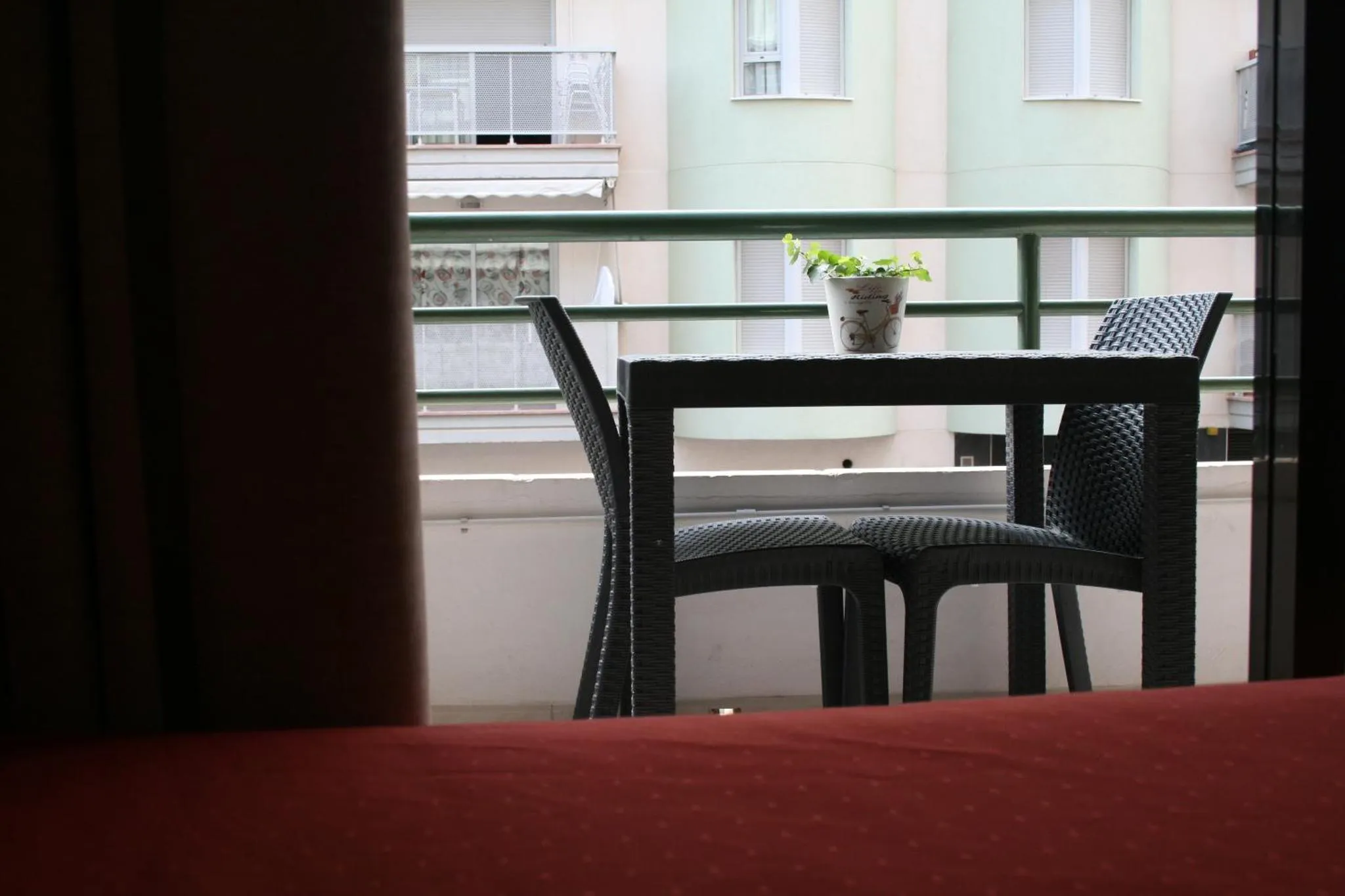 Une table et deux chaises sur un balcon ensoleillé.
