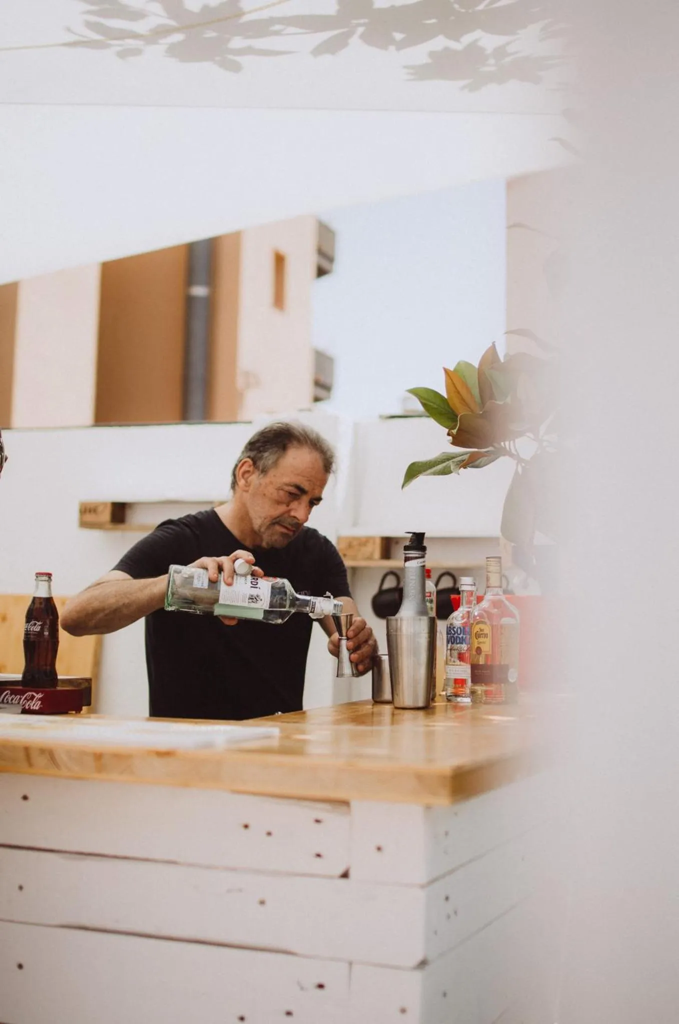 Un homme prépare des boissons derrière un comptoir en bois.