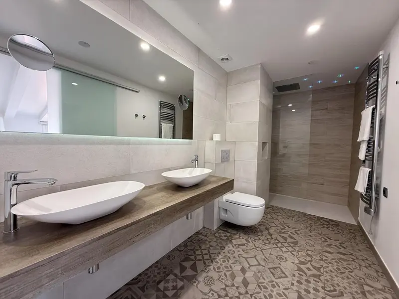 Une salle de bain moderne avec deux vasques et une douche à l'italienne.