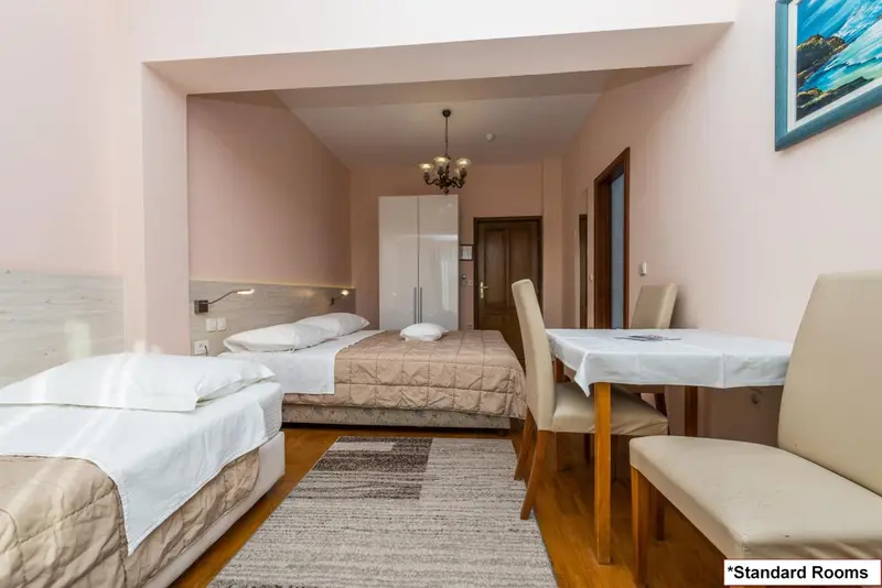 Une chambre lumineuse avec deux lits et une table.