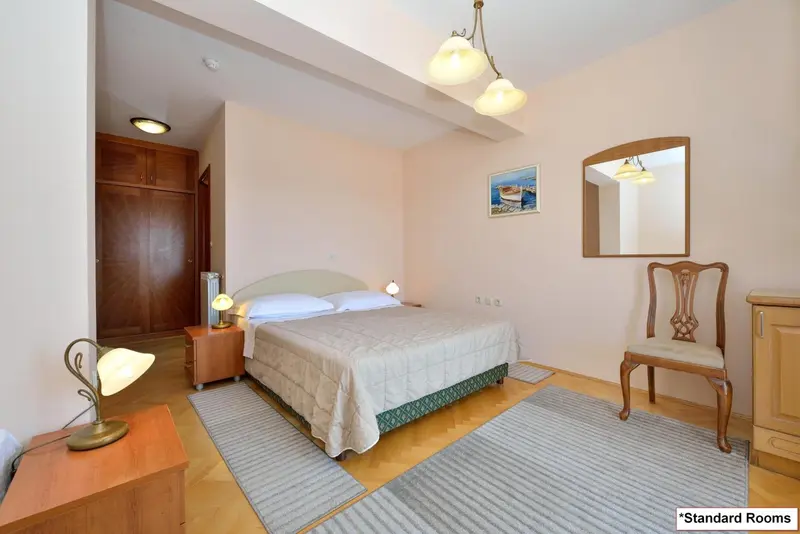 Une chambre lumineuse avec un lit double et un miroir.