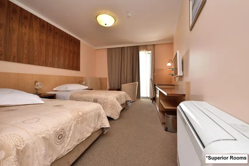Chambre avec deux lits simples et bureau.