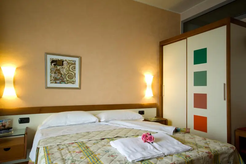 Une chambre lumineuse avec un lit double et une décoration murale.