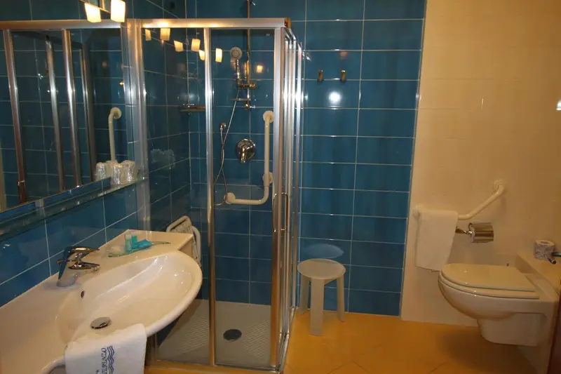 Une salle de bain lumineuse avec douche et lavabo.