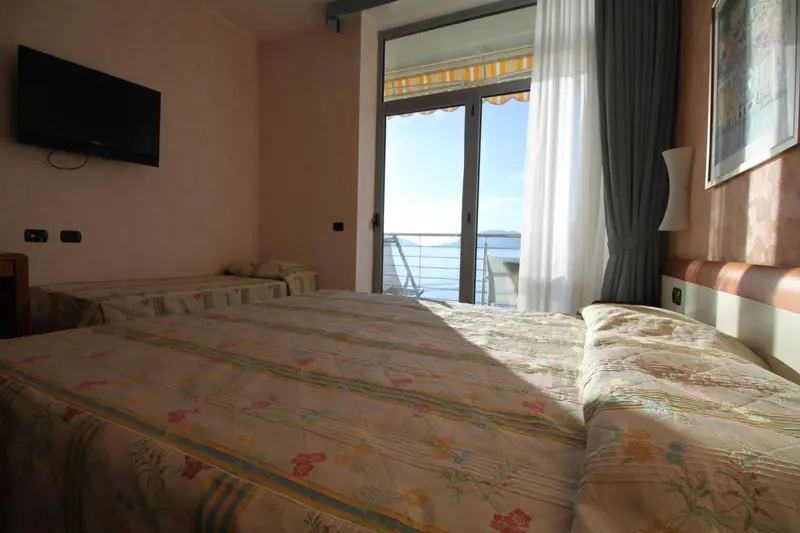 Une chambre lumineuse avec un lit et une vue sur la mer.