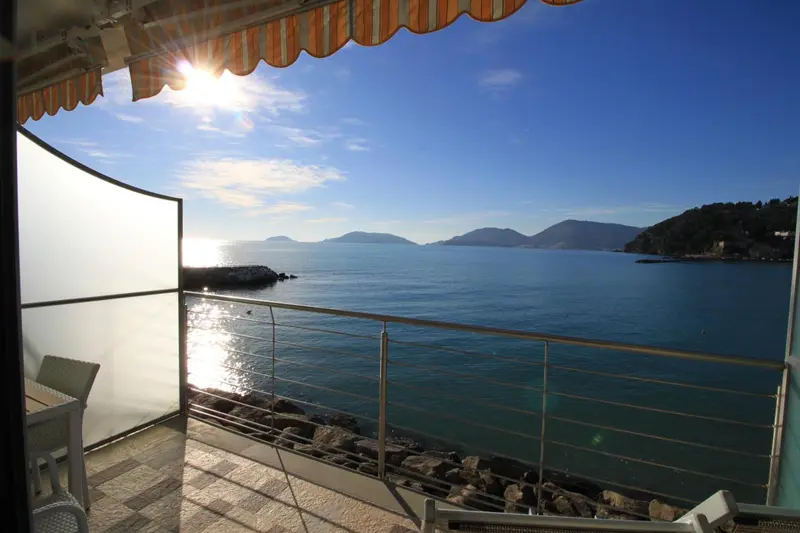 Vue sur la mer depuis une terrasse ensoleillée.