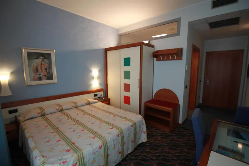 Une chambre d'hotel avec un lit et une armoire.