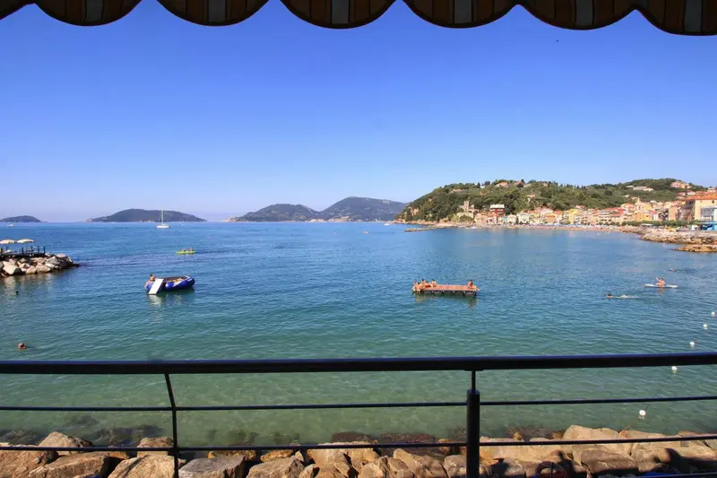 Vue sur une baie turquoise avec des bateaux et des îles verdoyantes.