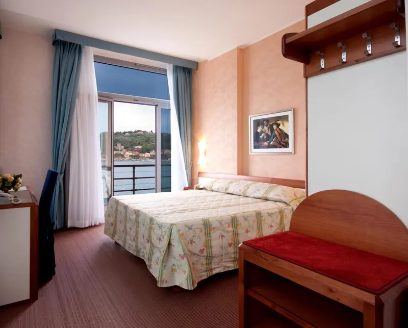 Une chambre lumineuse avec un lit double et une vue sur la mer.
