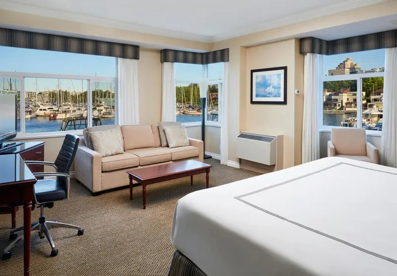 Une chambre lumineuse avec un canapé et une vue sur un port de plaisance.