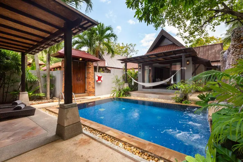 Petite piscine privee devant un bungalow avec terrasse couverte.