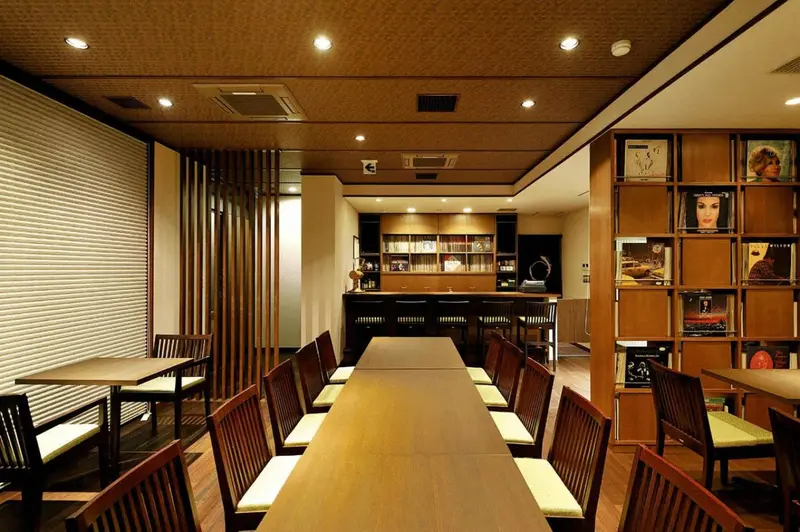 Une salle lumineuse avec des tables et des chaises en bois.