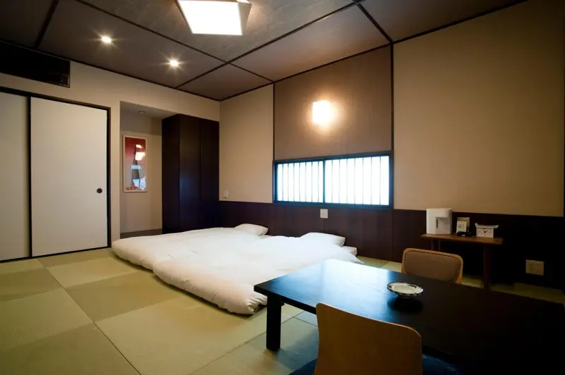 Une chambre avec un lit sur tatami et une petite table basse.