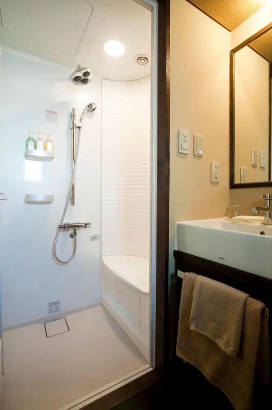 Une douche moderne avec un lavabo et un miroir.