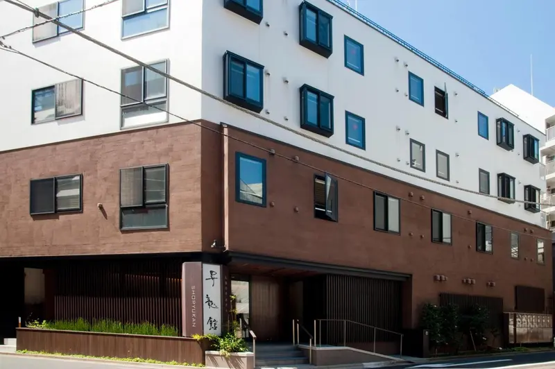 Façade d'un bâtiment moderne à deux étages avec des fenêtres rectangulaires.