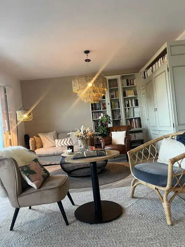Un salon chaleureux avec des fauteuils confortables et une décoration soignée.