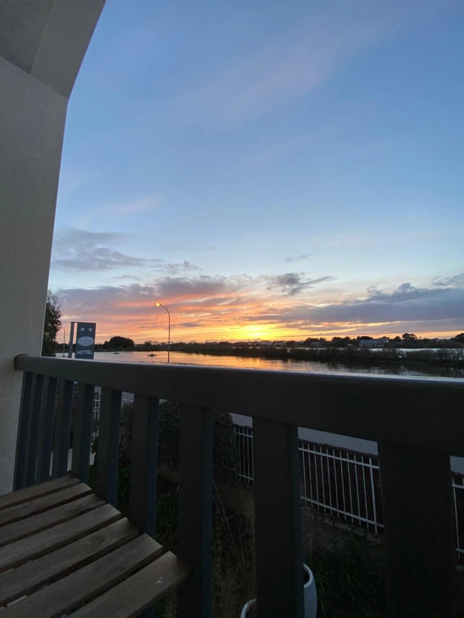 Coucher de soleil sur l'océan vu d'une terrasse d'hôtel.