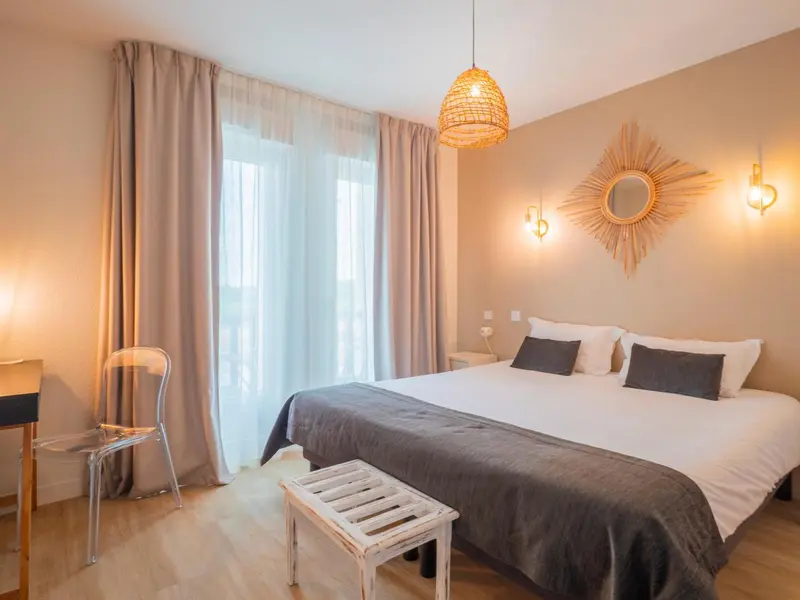 Une chambre lumineuse avec un lit double et un décor mural en forme de soleil.