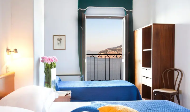 Chambre lumineuse avec vue sur la mer et un balcon.