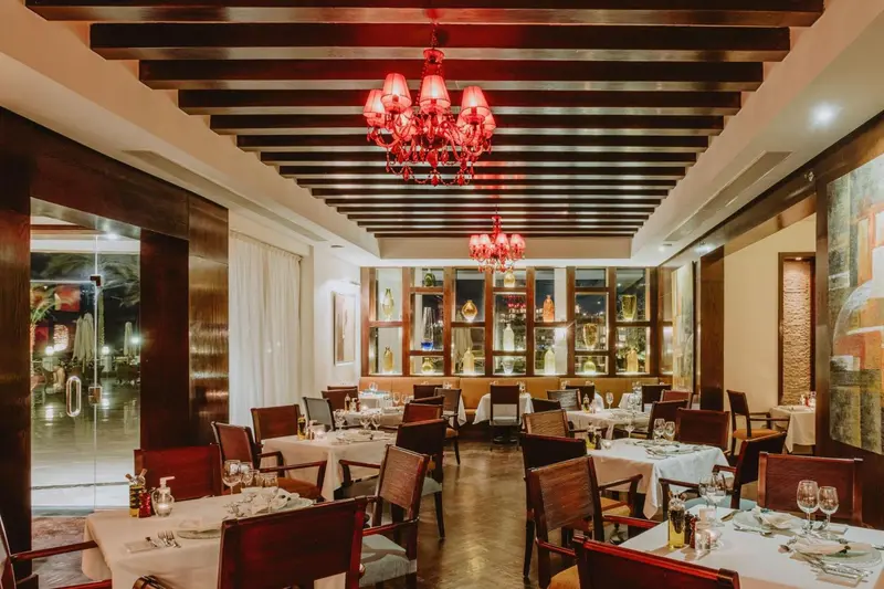 Une salle de restaurant élégante avec des tables dressées et un éclairage tamisé.