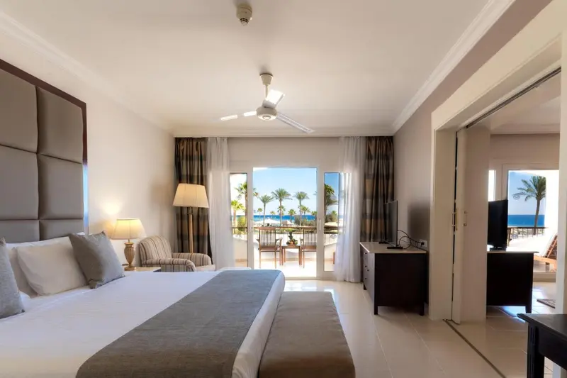 Une chambre lumineuse avec un grand lit et un accès à une terrasse.