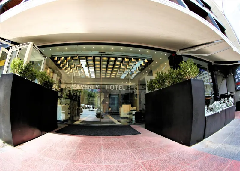 Entree d'un hotel avec marquise et jardinières.