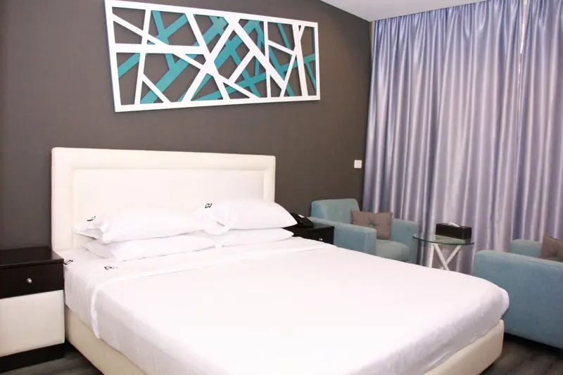 Une chambre avec un grand lit blanc et des tables de chevet.