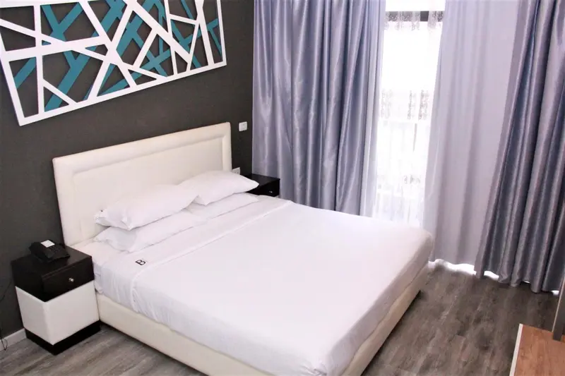 Une chambre lumineuse avec un grand lit recouvert de draps blancs.