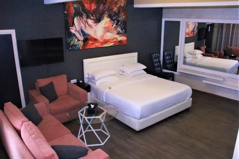 Une chambre spacieuse avec un grand lit et un coin salon.