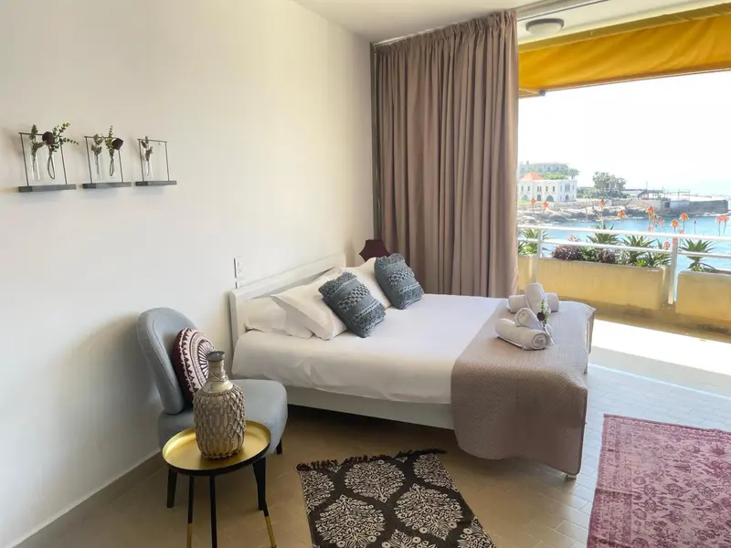 Une chambre lumineuse avec un lit confortable et une vue sur la mer.