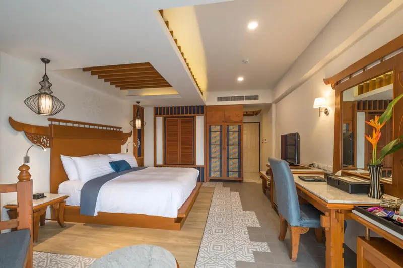 Une chambre lumineuse avec un grand lit et un espace bureau.